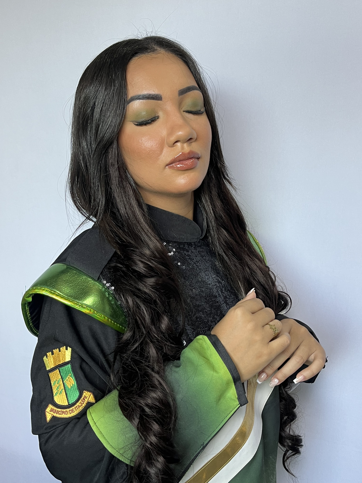 Cliente maquiada com acabamento glow e cabelo ondulado